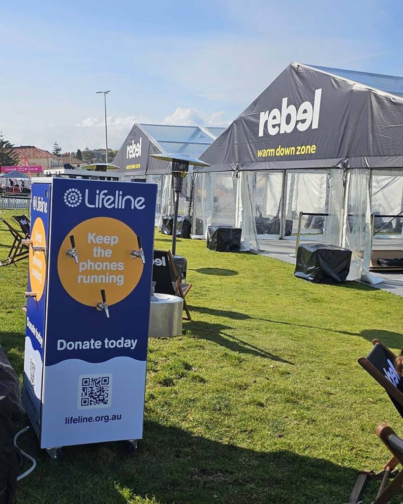 Donation box near event tents on grass field.
