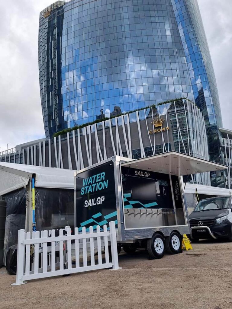 Water station setup near modern glass building.