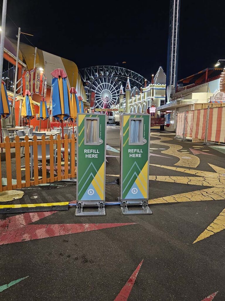 Amusement park at night with refill stations.