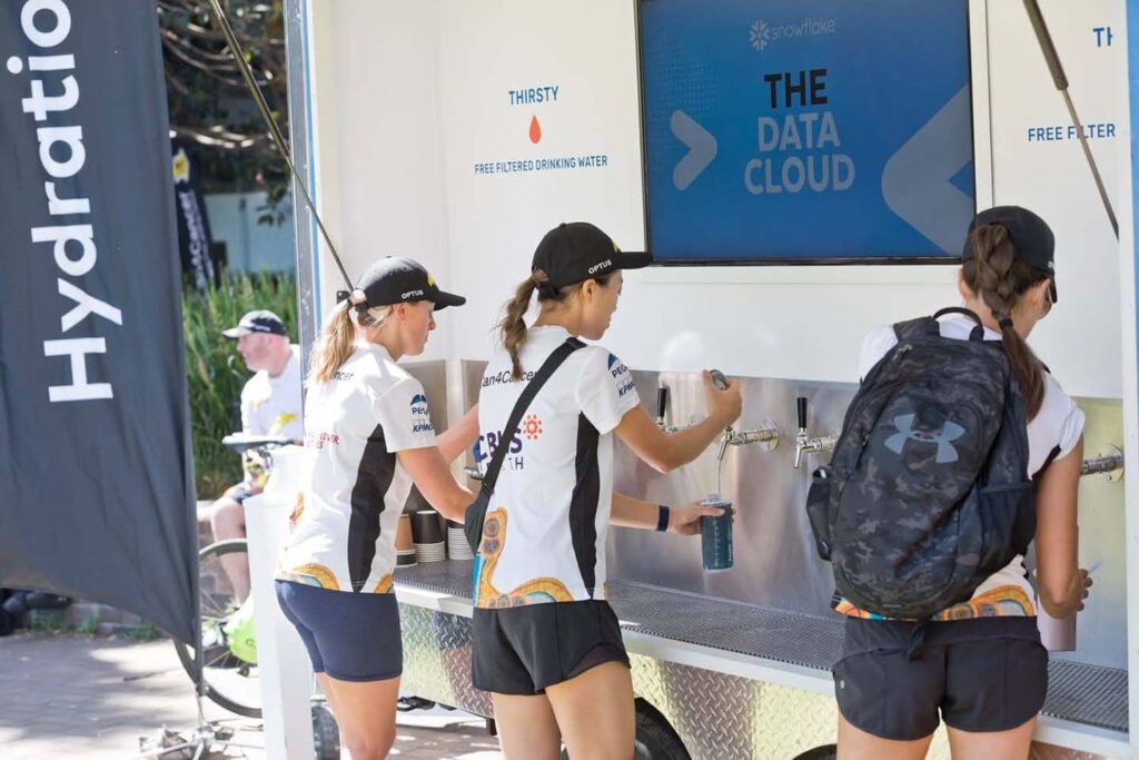 People filling water bottles at hydration station.