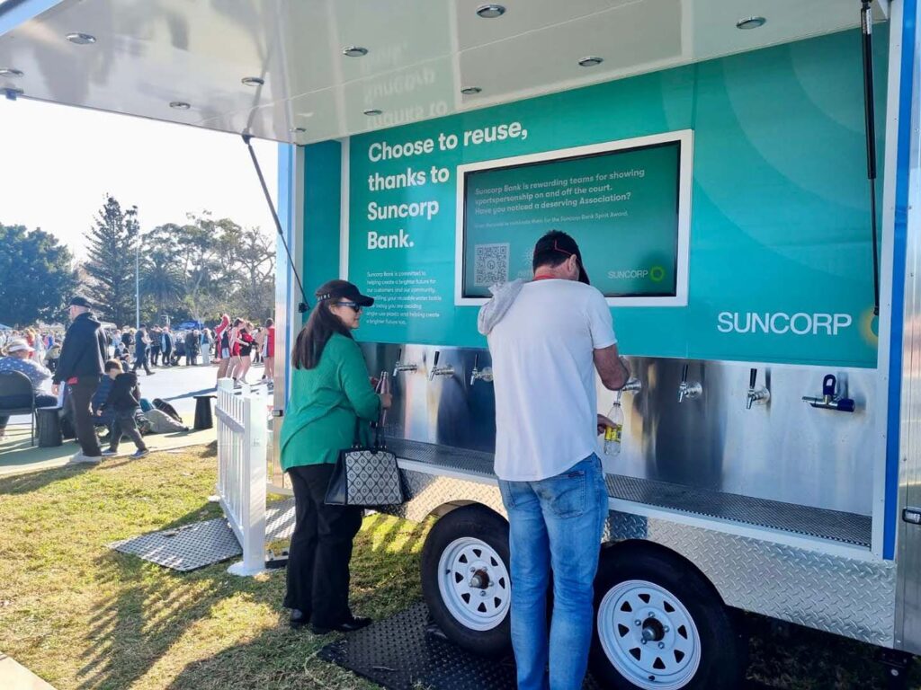 People refilling bottles at Suncorp water station event.