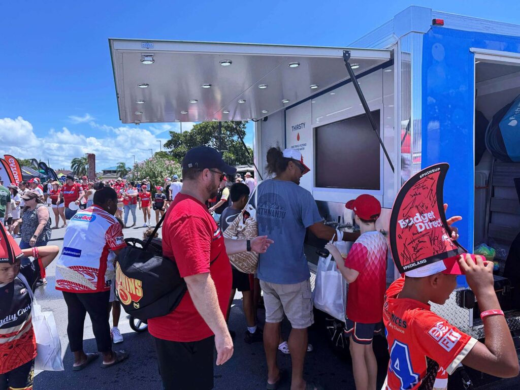 People at outdoor event near hydration station.