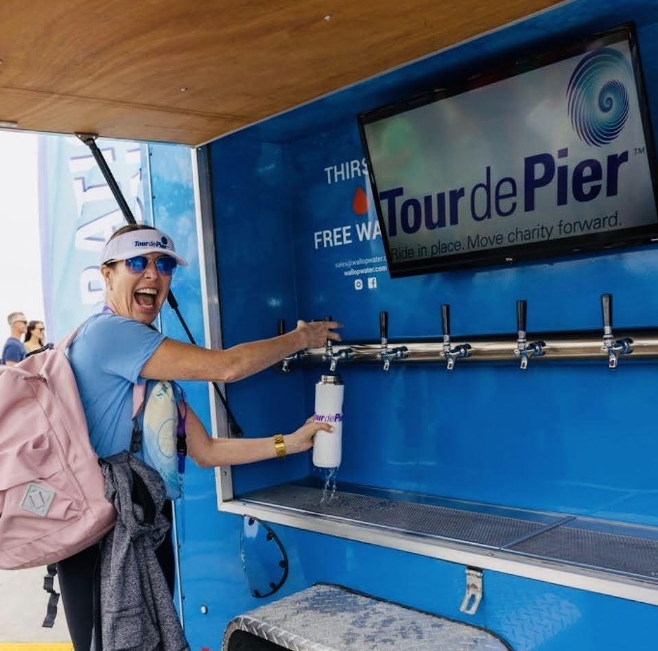 Smiling person fills water bottle at Tour de Pier.