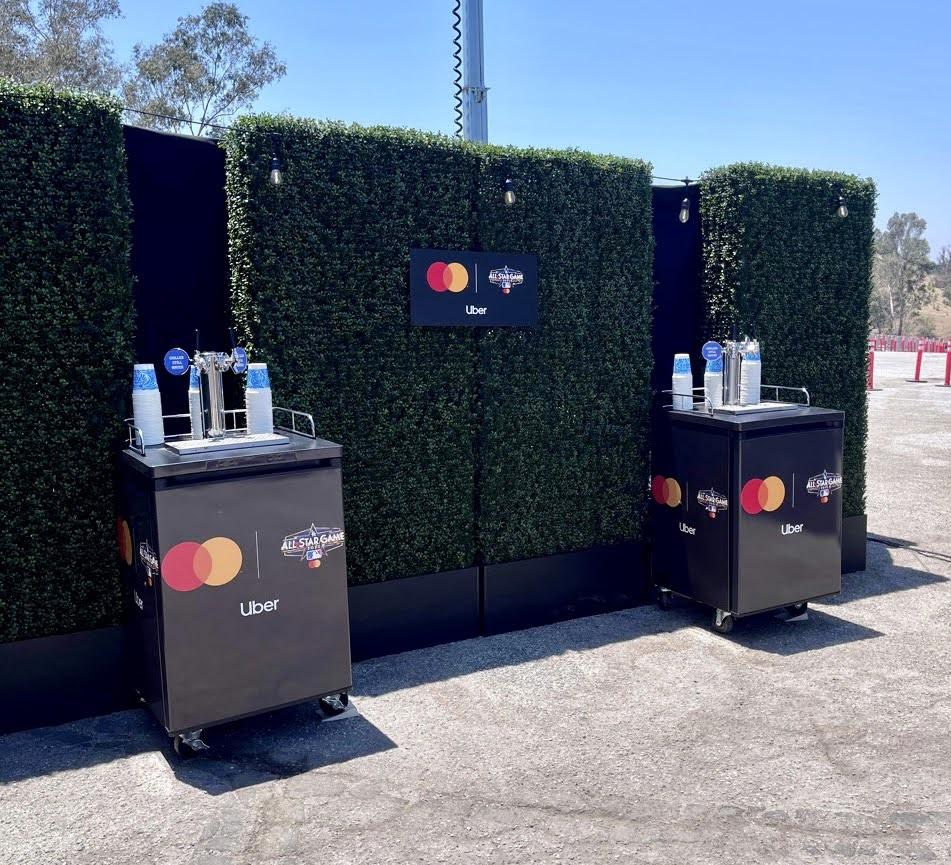 Outdoor beverage stations branded with Mastercard and Uber.