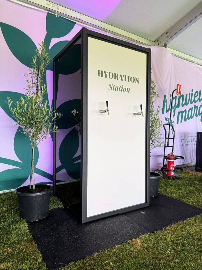 Hydration station with water taps at outdoor event.