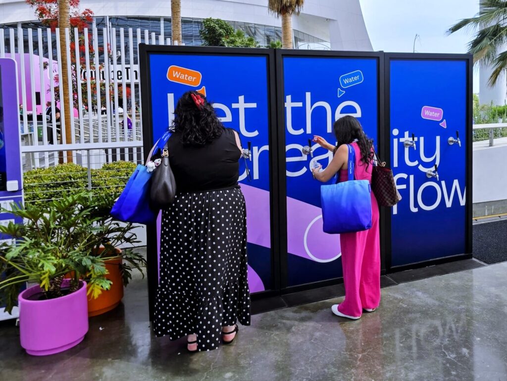 Two women filling water at outdoor station