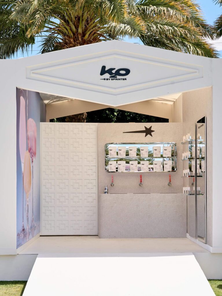 Modern outdoor skincare kiosk with palm trees overhead