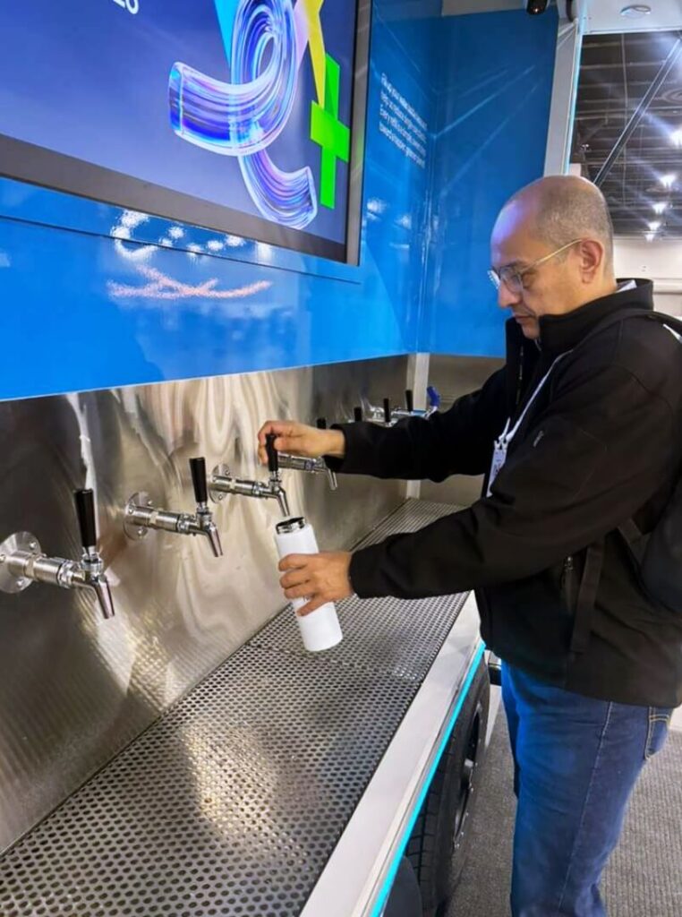 Man filling reusable bottle at water station