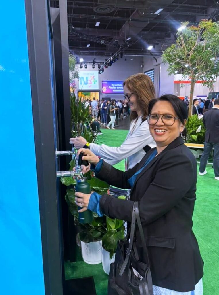 Women filling reusable water bottles at expo
