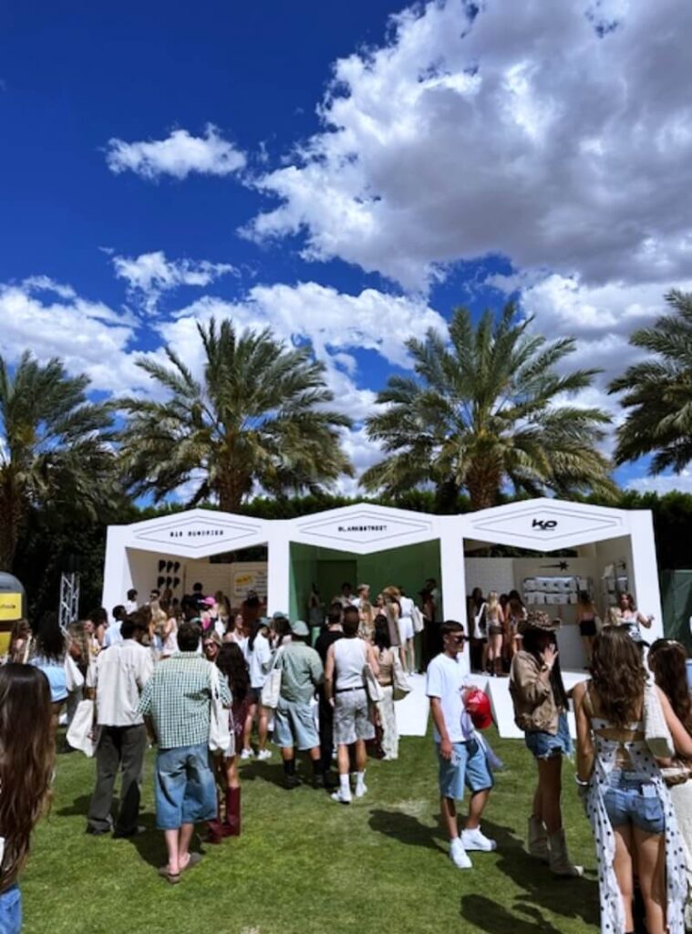 Outdoor event with booths and palm trees